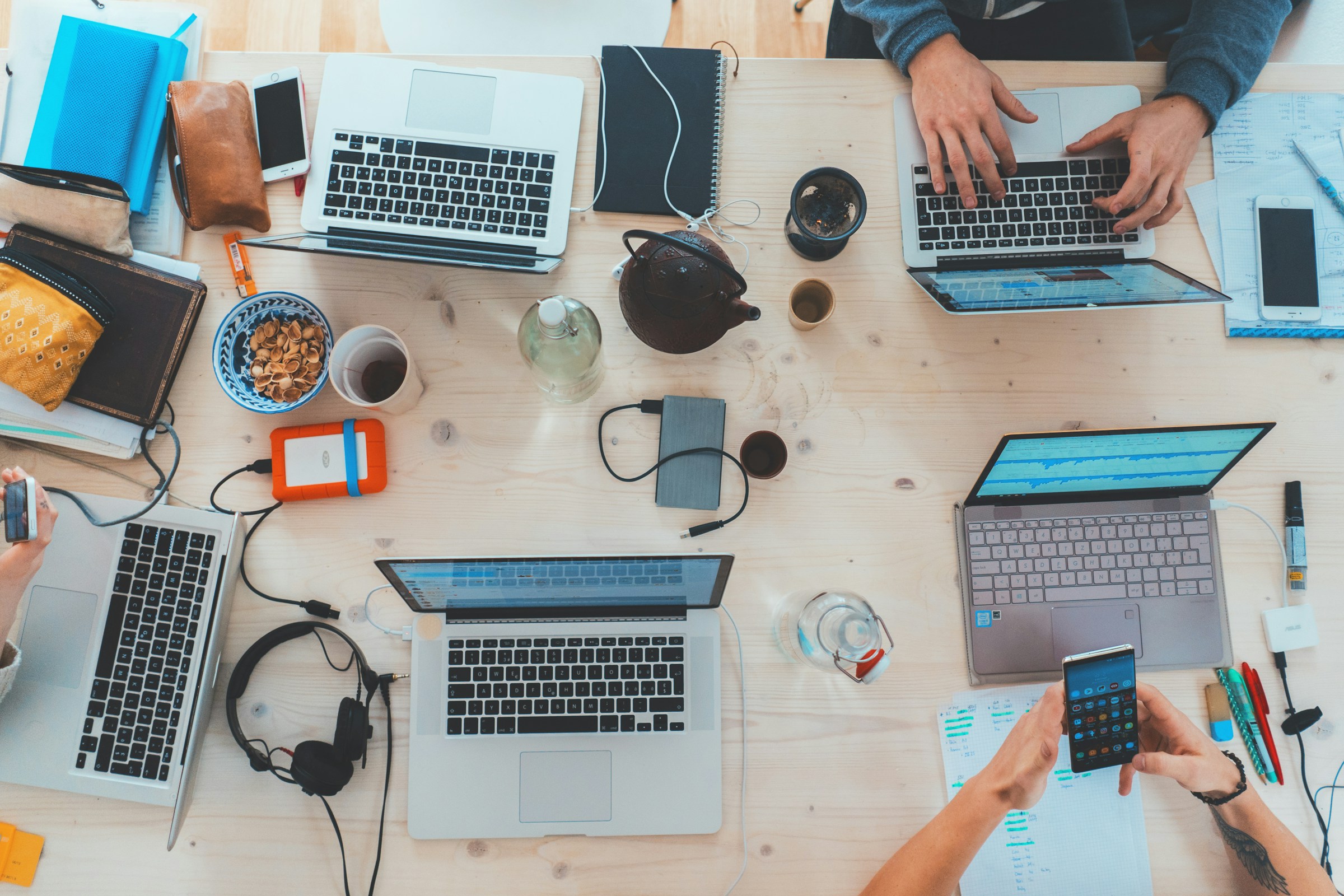 People collaborating around a shared desk in a modern workplace.